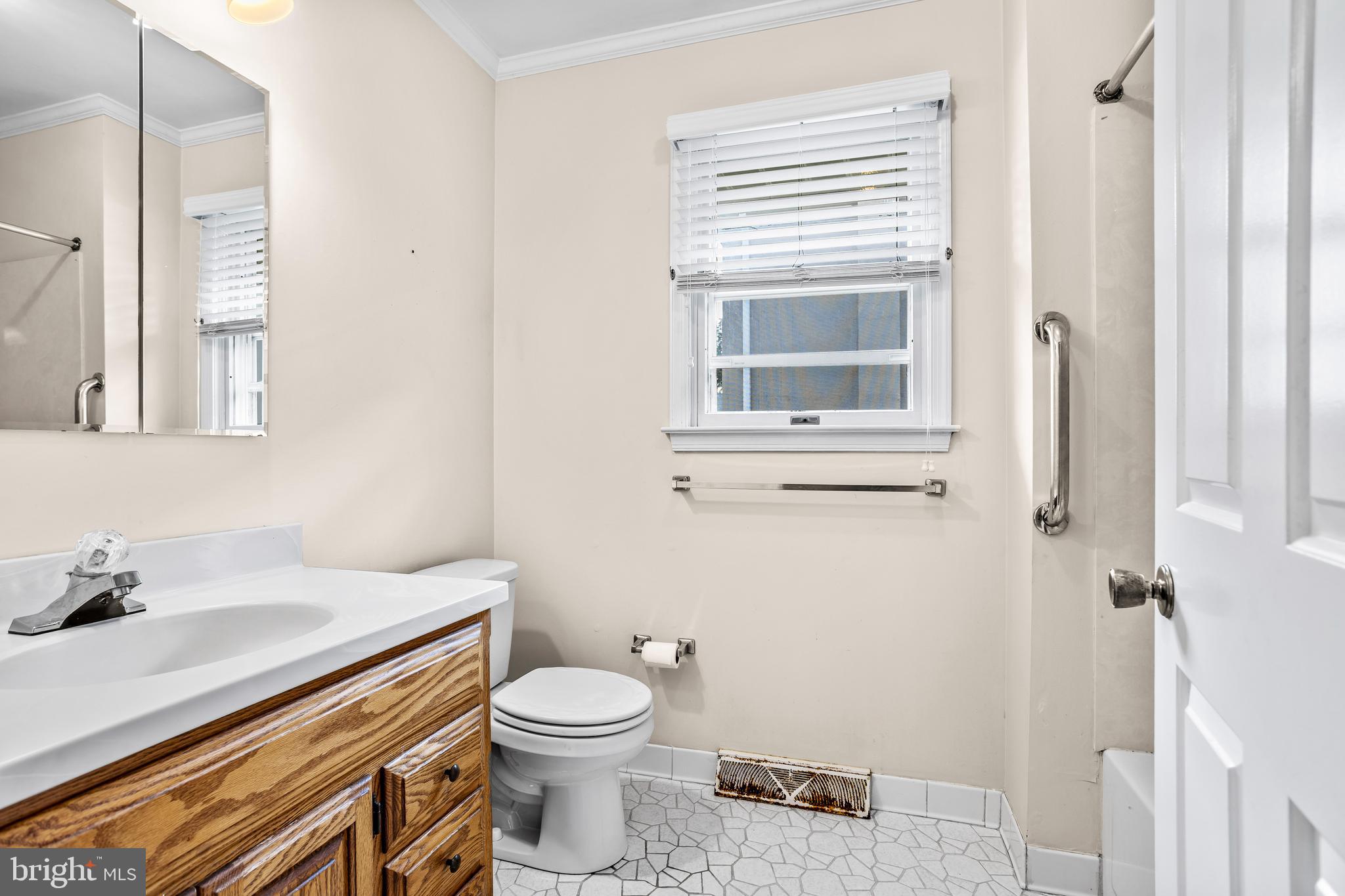 253 Saxer Avenue Springfield, PA 19064 - Photo 17 of 25 a bathroom with a sink a toilet and a window