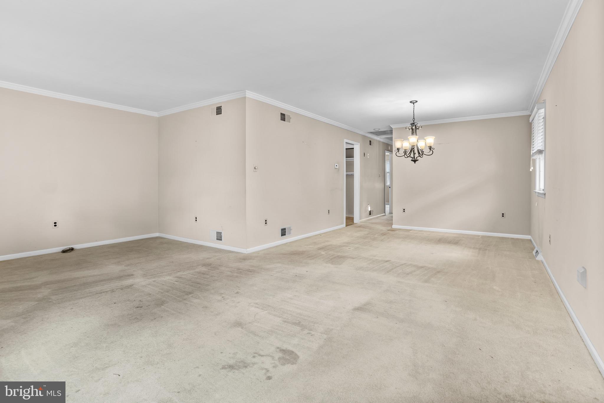 253 Saxer Avenue Springfield, PA 19064 - Photo 7 of 25 an empty room with a chandelier fan and windows