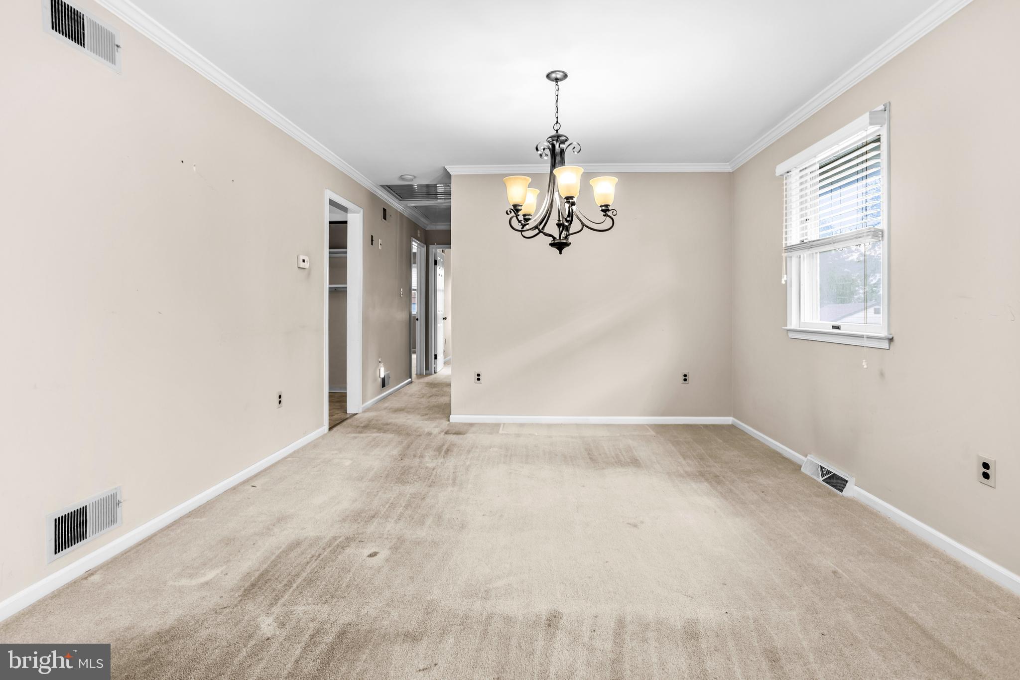 253 Saxer Avenue Springfield, PA 19064 - Photo 9 of 25 an empty room with a chandelier fan and wooden floor