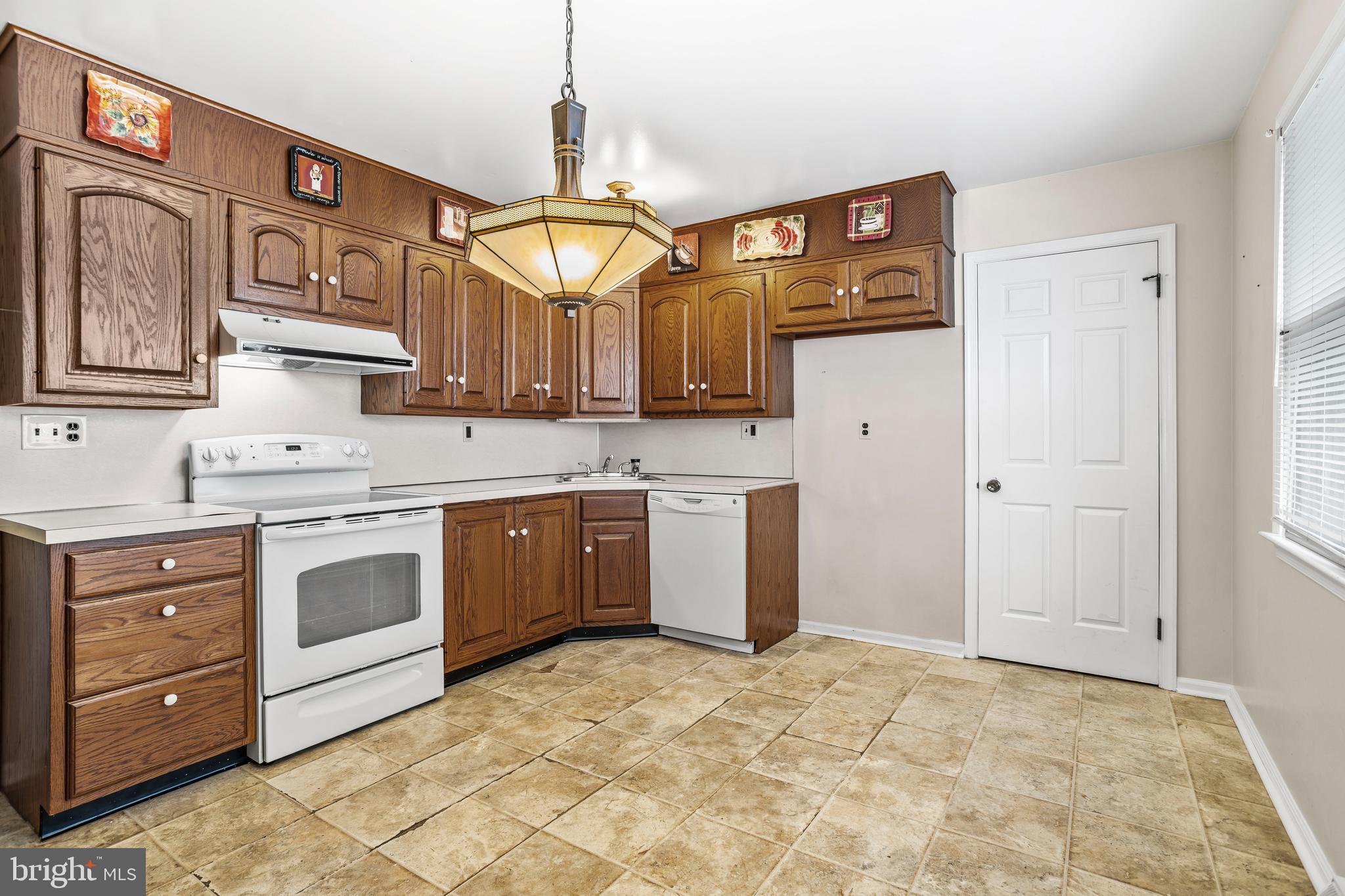 253 Saxer Avenue Springfield, PA 19064 - Photo 10 of 25 a kitchen with stainless steel appliances granite countertop a sink and cabinets