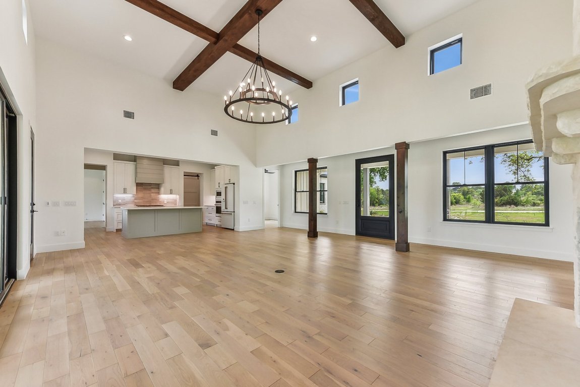 116 Tranquility Trail Spicewood, TX 78669 - Photo 11 of 40 a view of an empty room with a window and a kitchen