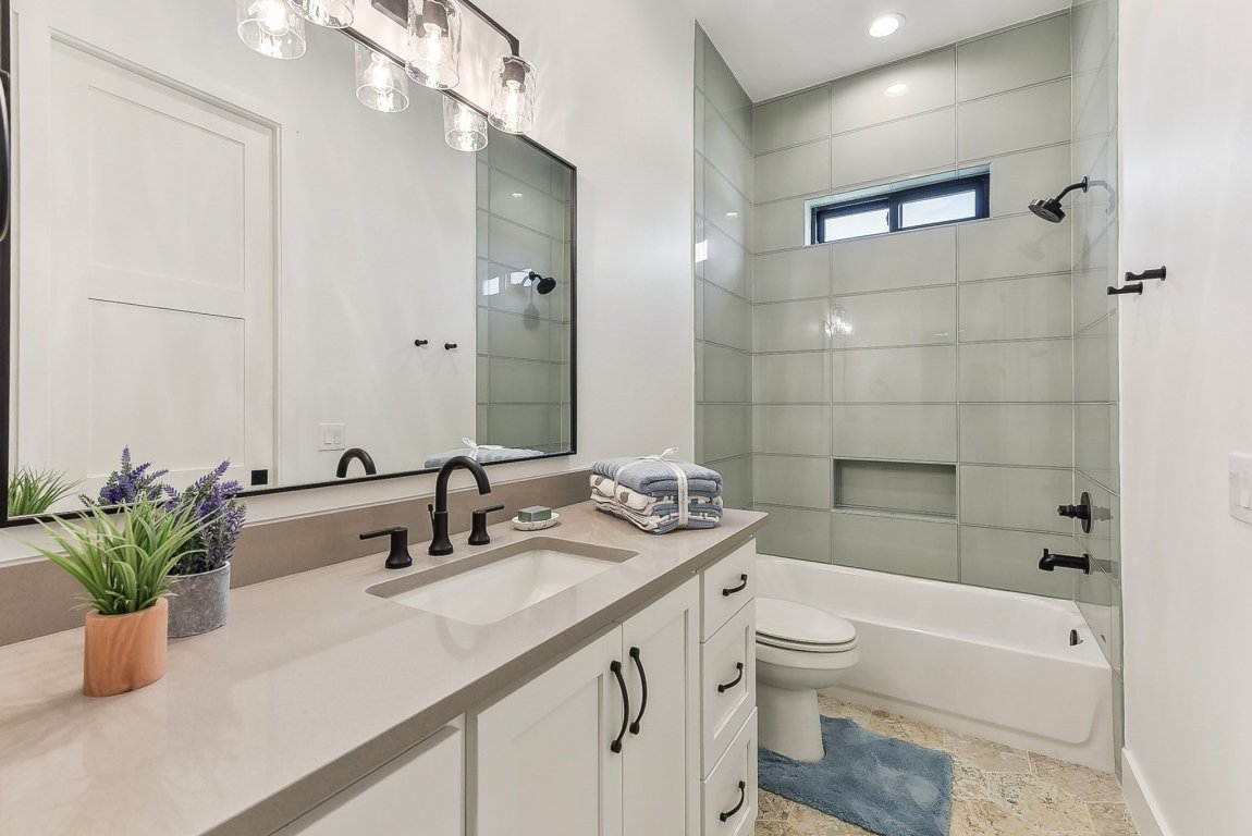 116 Tranquility Trail Spicewood, TX 78669 - Photo 29 of 40 a bathroom with a double vanity sink toilet and shower