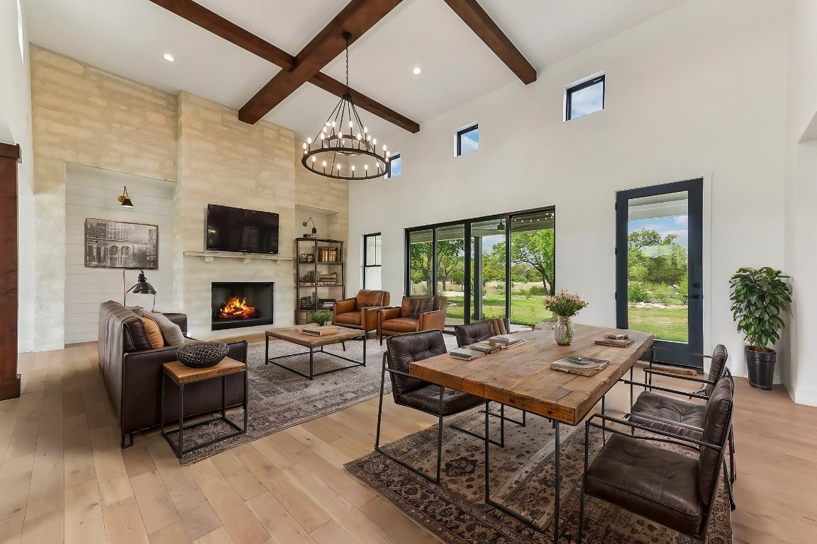 116 Tranquility Trail Spicewood, TX 78669 - Photo 10 of 40 a living room with furniture a fireplace and a large window