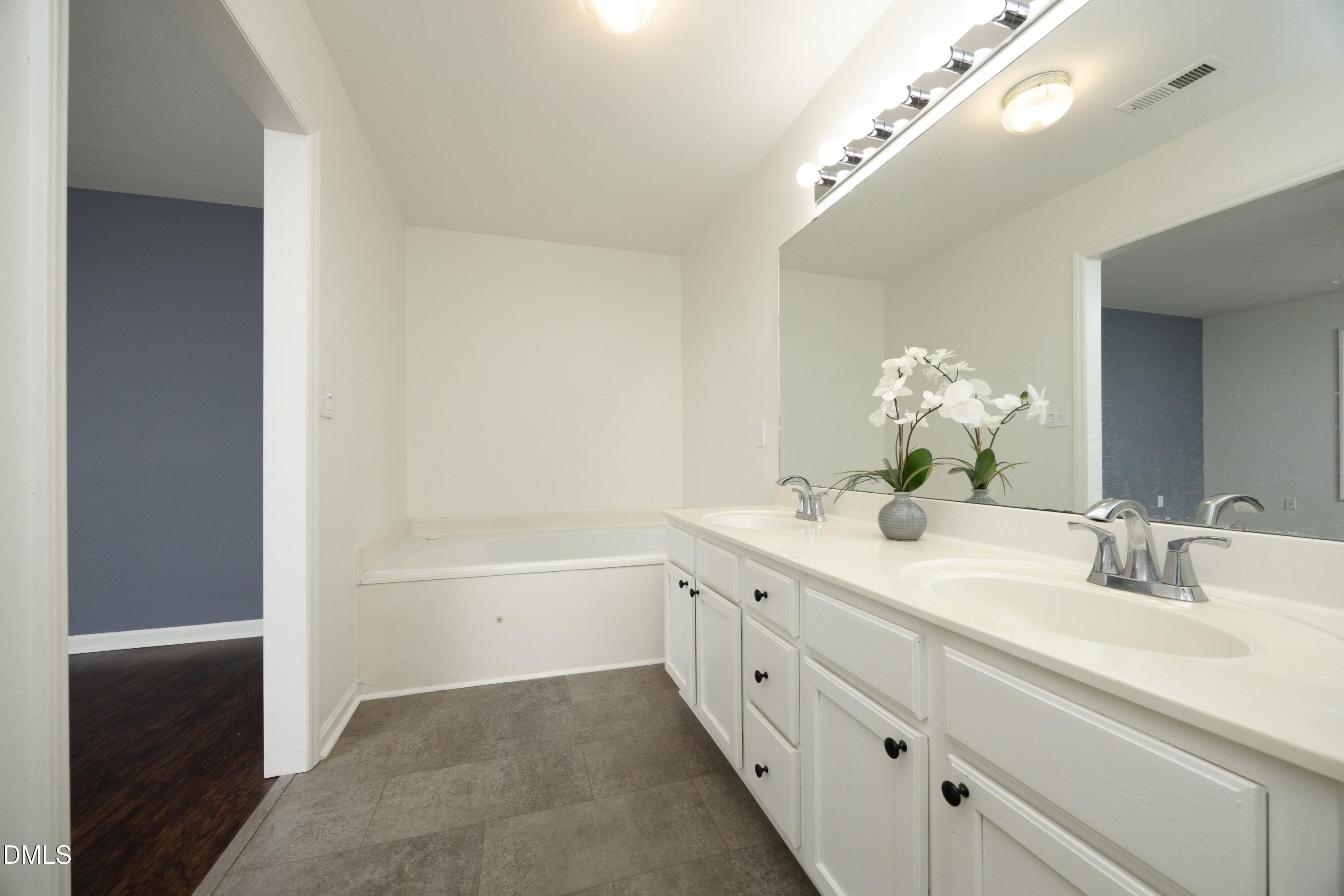 521 Renshaw Court Cary, NC 27518 - Photo 20 of 34 a bathroom with a bathtub a sink and a mirror