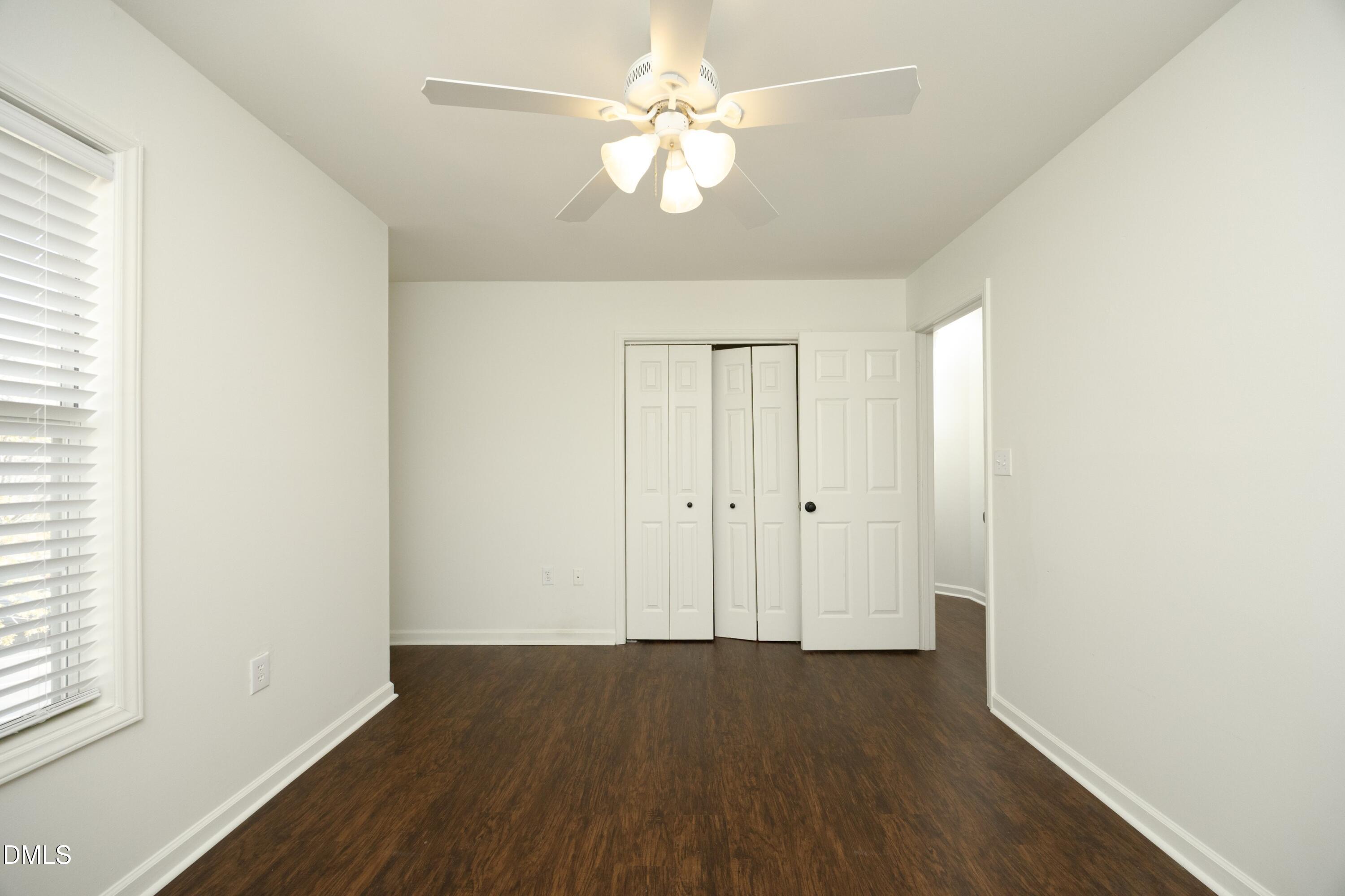 521 Renshaw Court Cary, NC 27518 - Photo 24 of 34 an empty room with wooden floor chandelier fan and windows