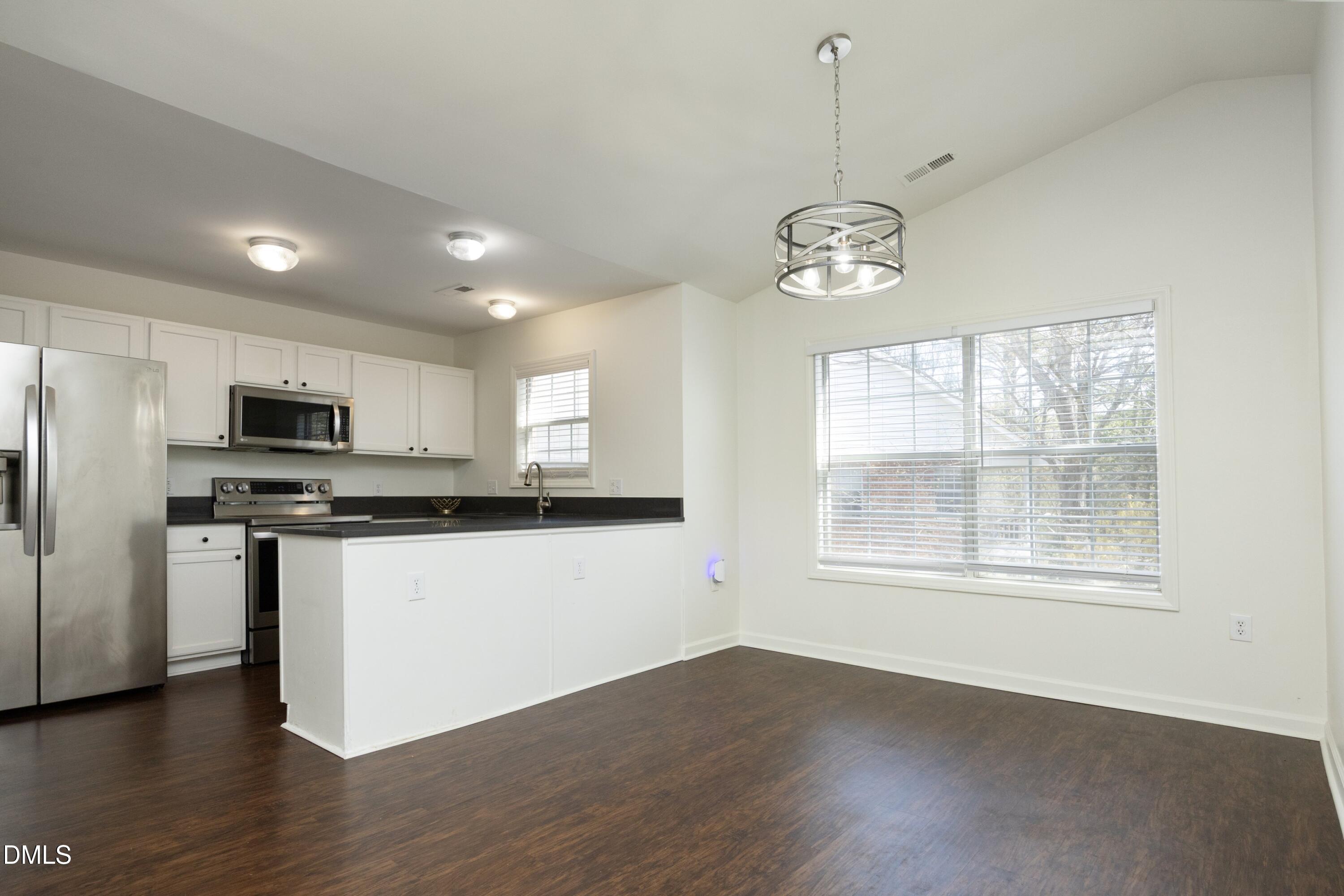 521 Renshaw Court Cary, NC 27518 - Photo 10 of 34 a view of an empty room with wooden floor and a window