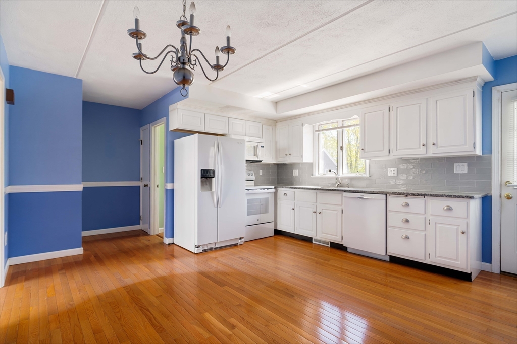 44 Salem Street, Unit C Wakefield, MA 01880 - Photo 11 of 26 a kitchen with stainless steel appliances granite countertop a refrigerator a sink dishwasher a stove and white cabinets with wooden floor