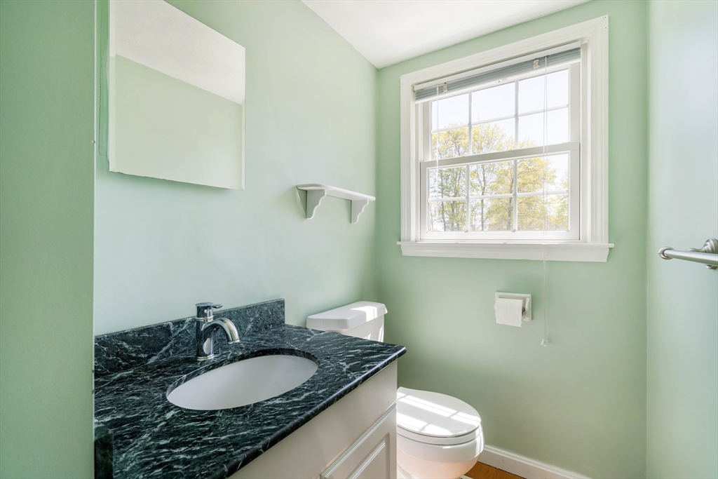 44 Salem Street, Unit C Wakefield, MA 01880 - Photo 13 of 26 a bathroom with a granite countertop toilet a sink a mirror and a window