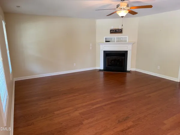 a view of a livingroom with a fireplace and a ceiling fan
