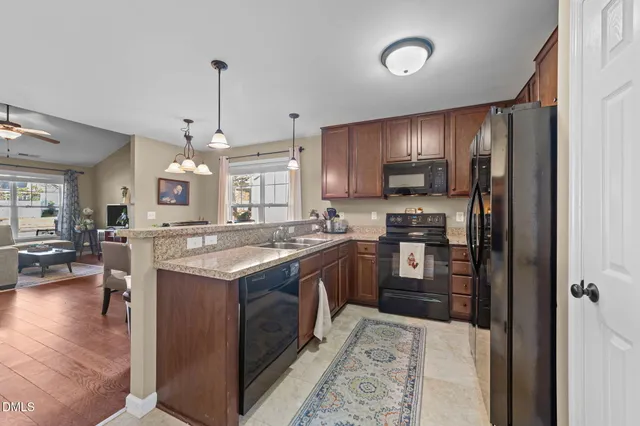 a kitchen with stainless steel appliances granite countertop a stove refrigerator and cabinets