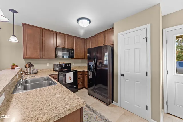 a kitchen with a refrigerator sink and wooden cabinets