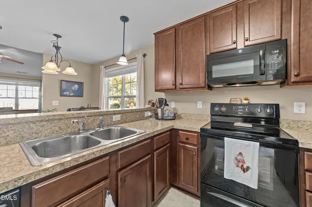 a kitchen with stainless steel appliances granite countertop a sink stove and microwave