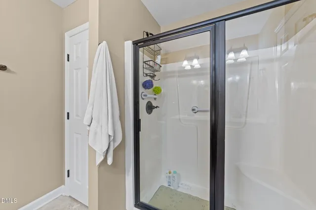 a bathroom with a glass shower door and a shower