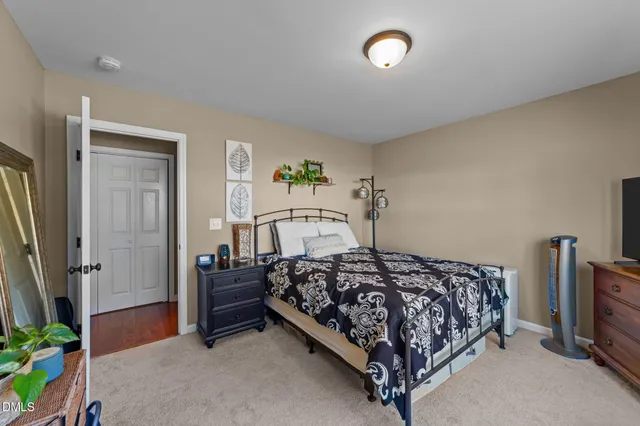 a bedroom with a bed and a tv on a dresser