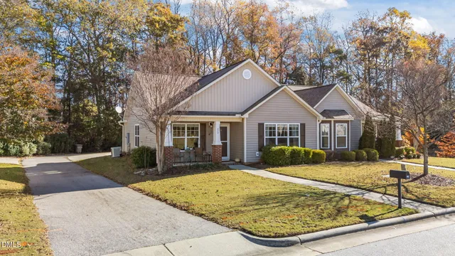 a view of a white house with a yard and large trees
