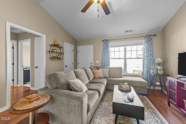 a living room with furniture a flat screen tv and a window