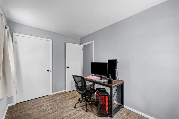 a view of a workspace with furniture and wooden floor