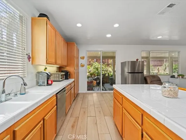 a large kitchen with stainless steel appliances a large counter top a stove a chimney a sink and cabinets