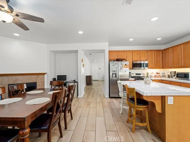 a kitchen with stainless steel appliances granite countertop a table chairs and a refrigerator