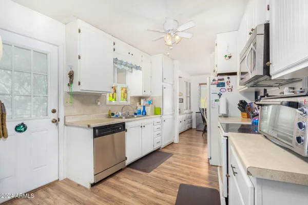 a kitchen with stainless steel appliances granite countertop a lot of counter space and wooden floors