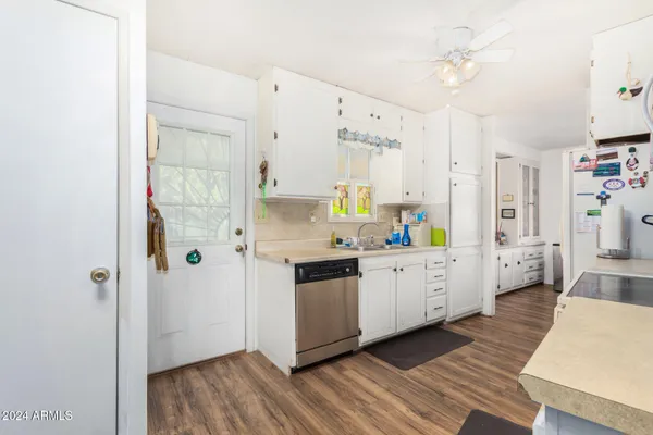 a large kitchen with a wooden floor and a refrigerator
