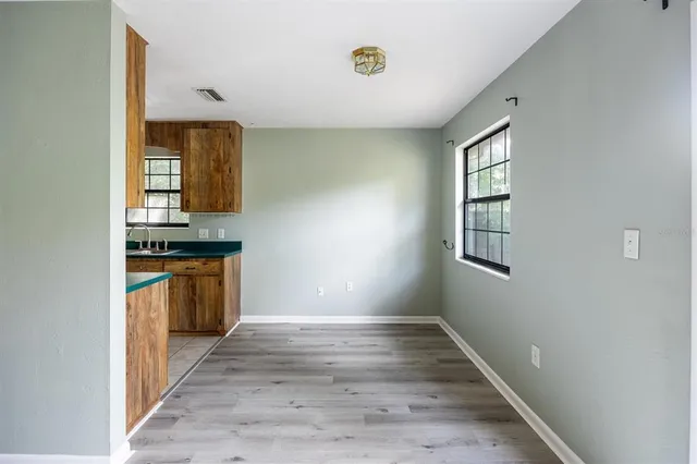 a view of kitchen with stove and wooden cabinets