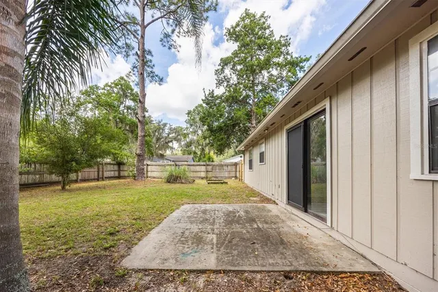 a view of a house with a yard and large tree