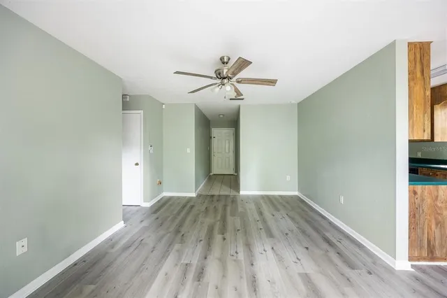 a view of a room with wooden floor and a ceiling fan