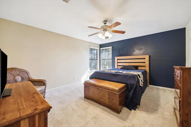 a bedroom with a bed and ceiling fan