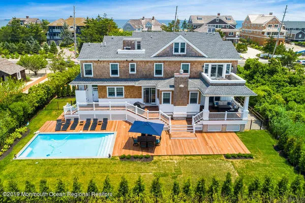 an aerial view of a house with a lot of trees houses and lake view