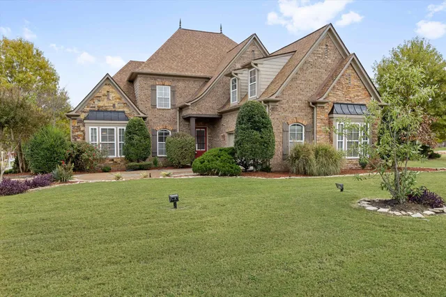 a view of a big house with a big yard and potted plants