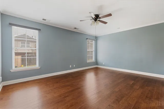 wooden floor in an empty room with a fireplace and a window