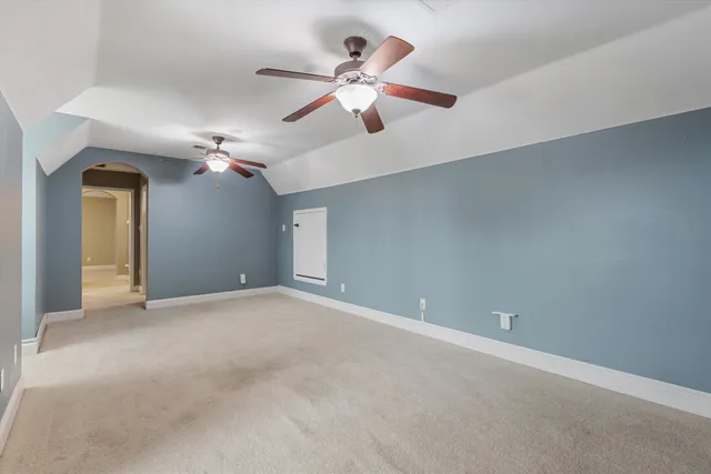 en empty room with ceiling fan and window