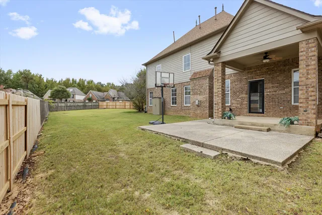 an empty room with chandelier fan and windows