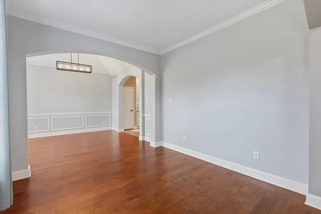 an empty room with wooden floor and mirror