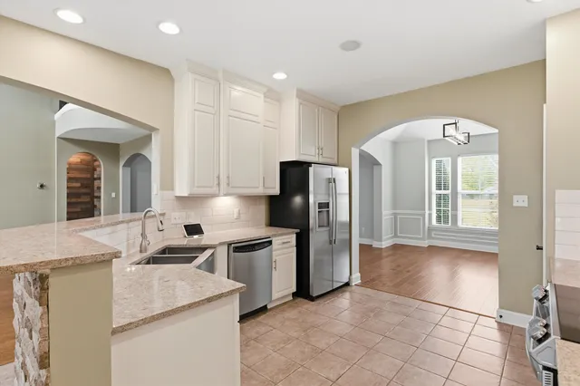 a kitchen with stainless steel appliances granite countertop a refrigerator and a sink