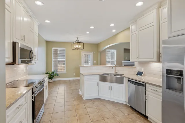 a kitchen with stainless steel appliances granite countertop a sink and dishwasher a stove top oven with wooden floor