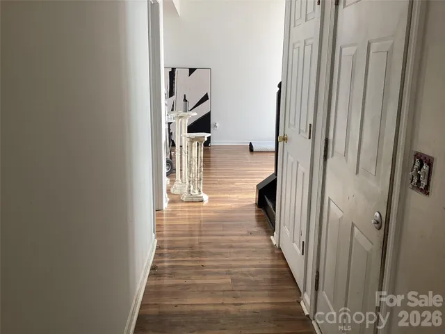a view of a hallway with wooden floor and staircase