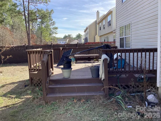 a view of a patio with table and chairs with wooden fence