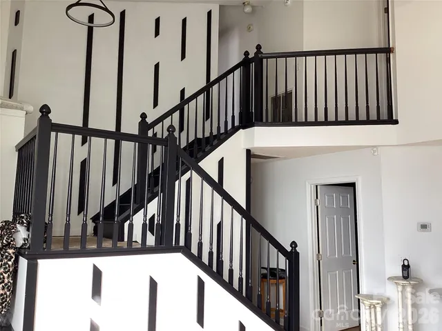 a view of staircase with lots of frames on wall and wooden floor