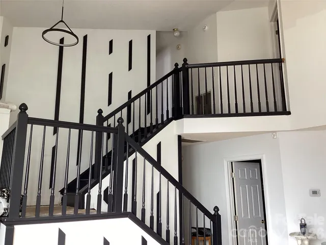 a view of staircase with lots of frames on wall and a window