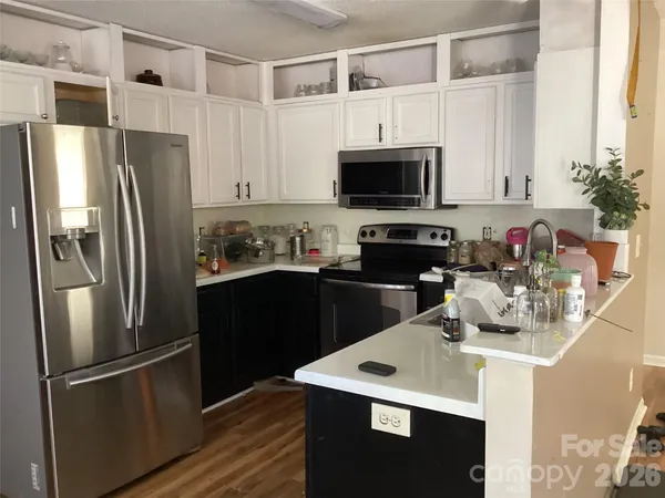 a kitchen with stainless steel appliances a refrigerator sink and microwave