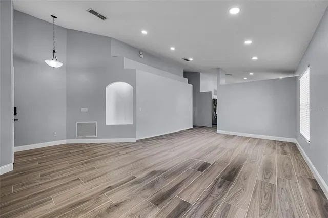 a kitchen with stainless steel appliances granite countertop a refrigerator a stove a sink dishwasher and a oven with wooden floor