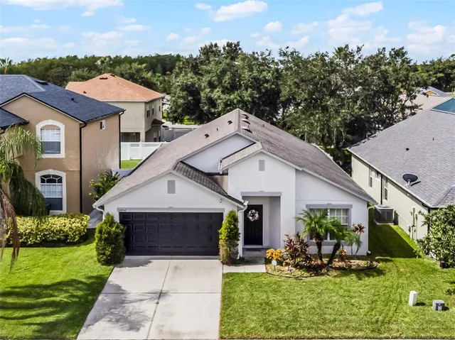 a view of house with garden and tall tress