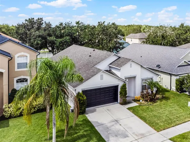 a aerial view of a house with a yard and potted plants