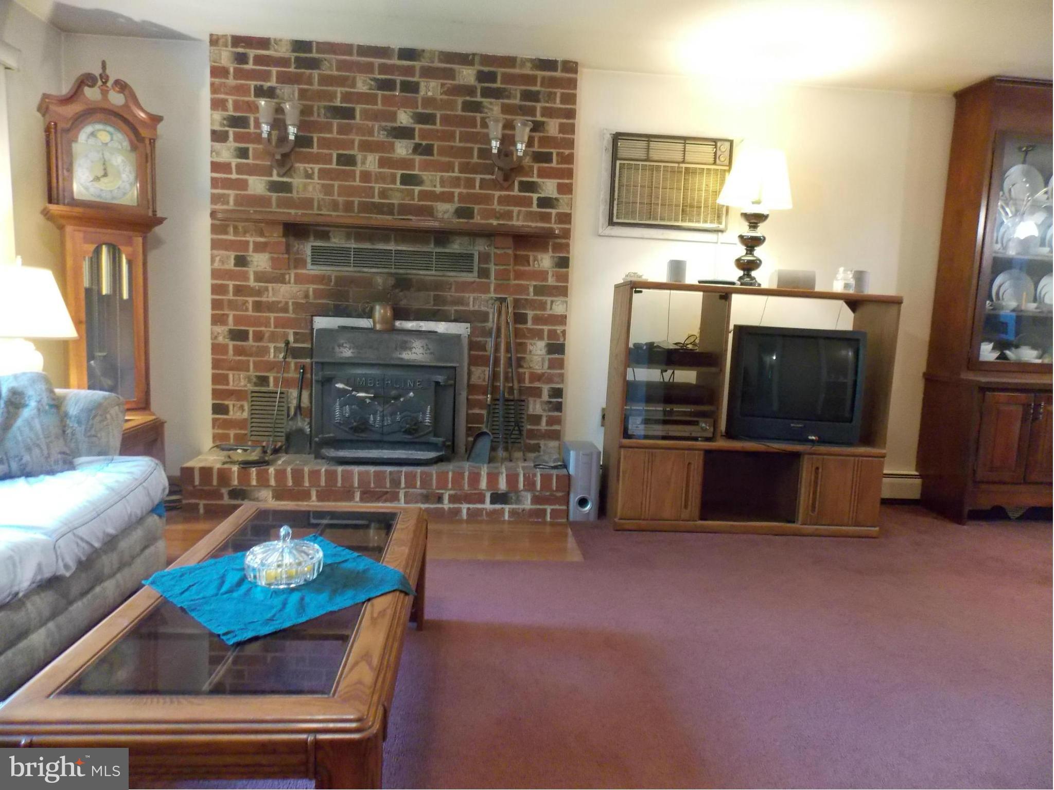 3039 Menges Mill Road Taneytown, MD 21787 - Photo 4 of 25 a living room with furniture a flat screen tv and a fireplace