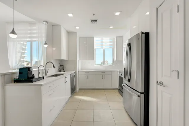 a large kitchen with a large counter top sink and stainless steel appliances