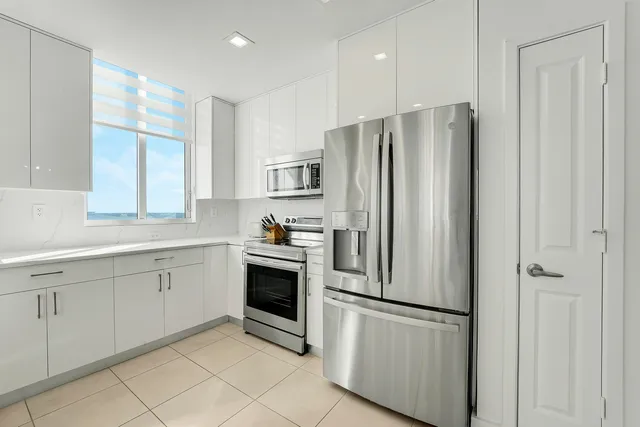 a kitchen with stainless steel appliances a refrigerator sink and cabinets