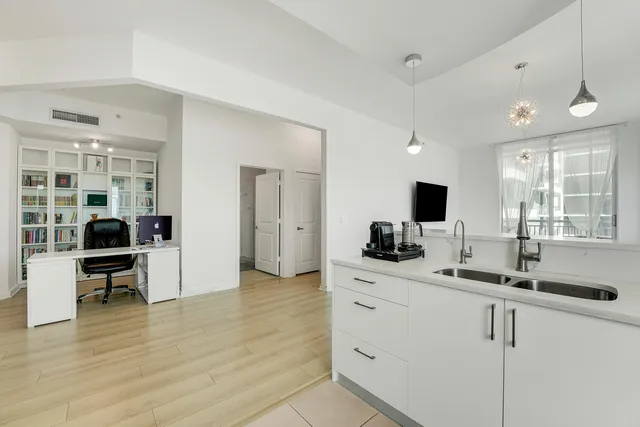 a bedroom with a bed wooden floor and a flat tv screen
