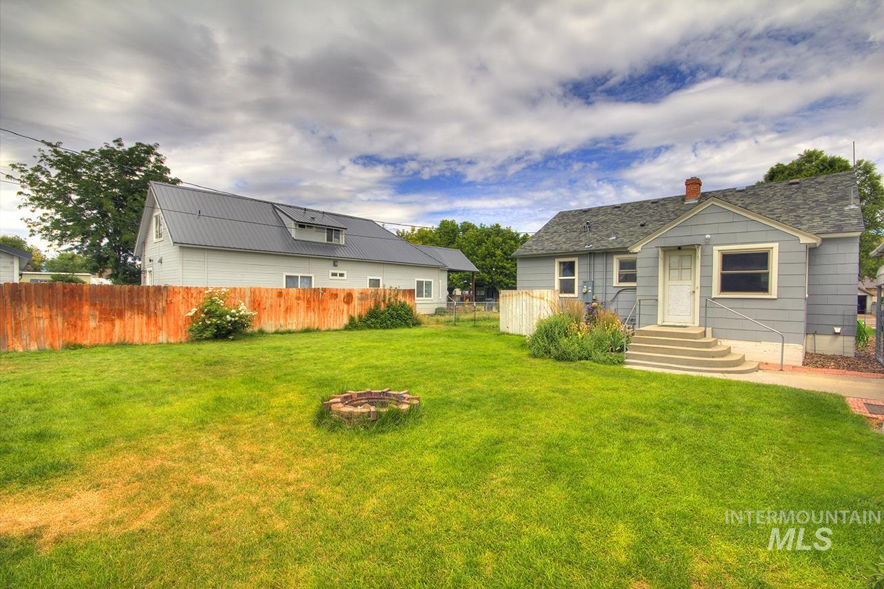 351 West Main Street South Vale, OR 97918 - Photo 25 of 33 Expansive grassy yard featuring a wood privacy fence and a stone fire pit